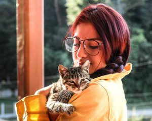 Kayla holding a cat on her shoulder