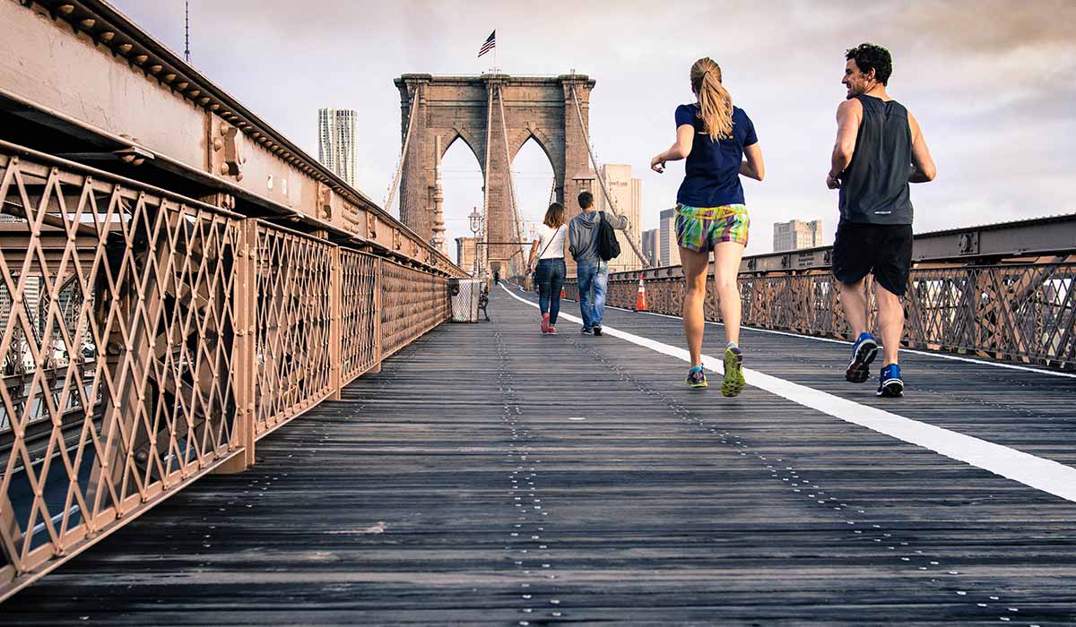 Woman and man running on the Brooklyn bridge