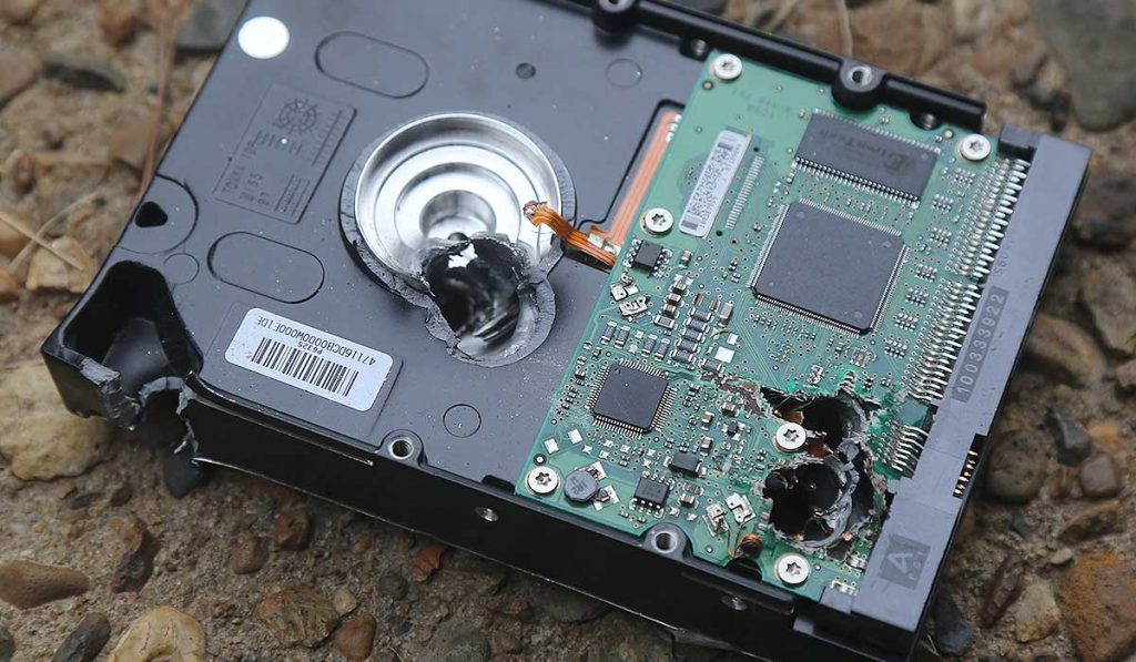 Hard drive that has been shot through with multiple bullets