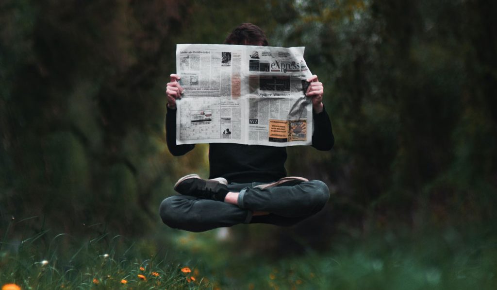 levitating man reading newspaper