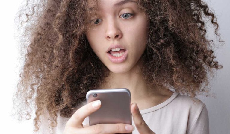 Surprised woman looking at website on her phone